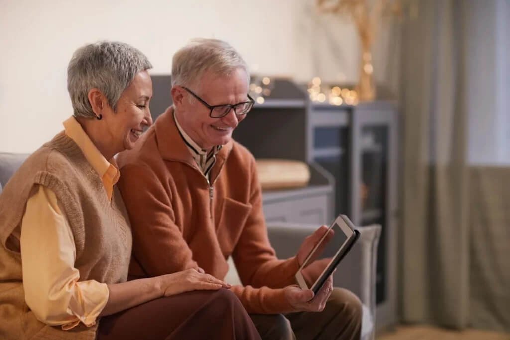 happy old couple looking at the tablet alzheimer's research volunteers